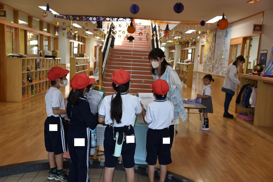 明るい光が入る園舎の共用スペースを歩く園児たち
