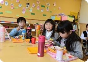 教室で友だちと一緒に給食を楽しむ子どもたち