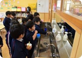 洗面台に並んで歯磨きをする子どもたち
