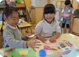 机を囲んで教具に取り組む子どもたち