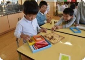 木製のはめこみ教具に取り組む子どもたち