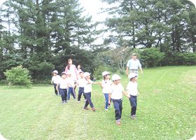 芝生の広場を元気に走る子どもたち
