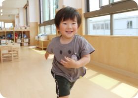 笑顔で保育室を歩く子ども