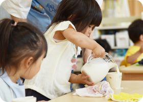 水差しを使って自分で水を注ぐ子ども