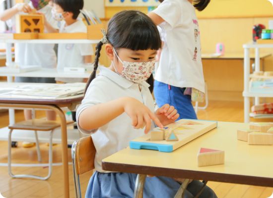 教具に集中して取り組む園児