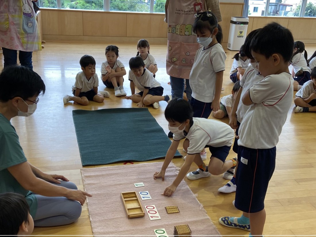 保育室で、先生と一緒に教具に取り組む幼稚園部の園児たち