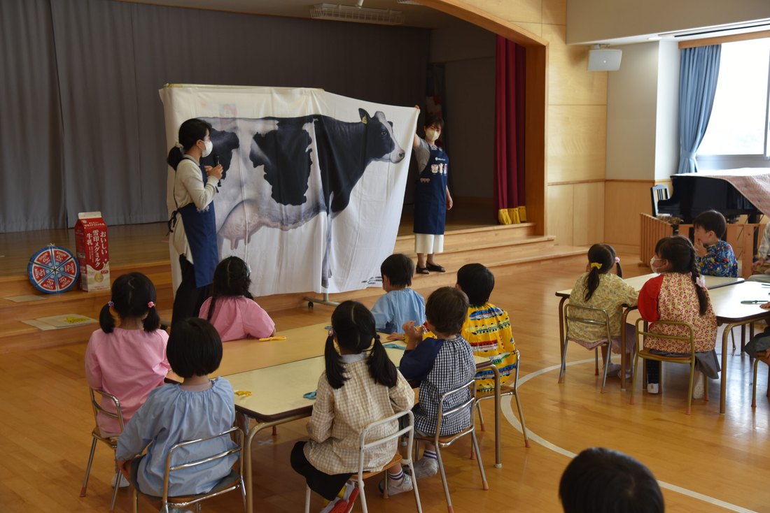 保育室で、先生の人形劇を見る保育園部の園児たち