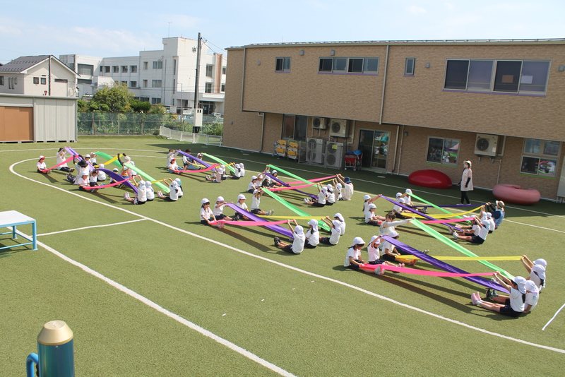 園庭いっぱいに用具を広げて、みんなで体を動かす園児たち