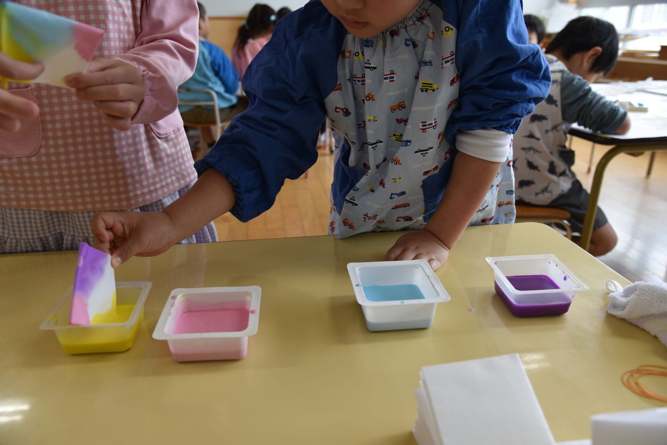 制作活動に取り組む園児に、先生が寄り添う様子